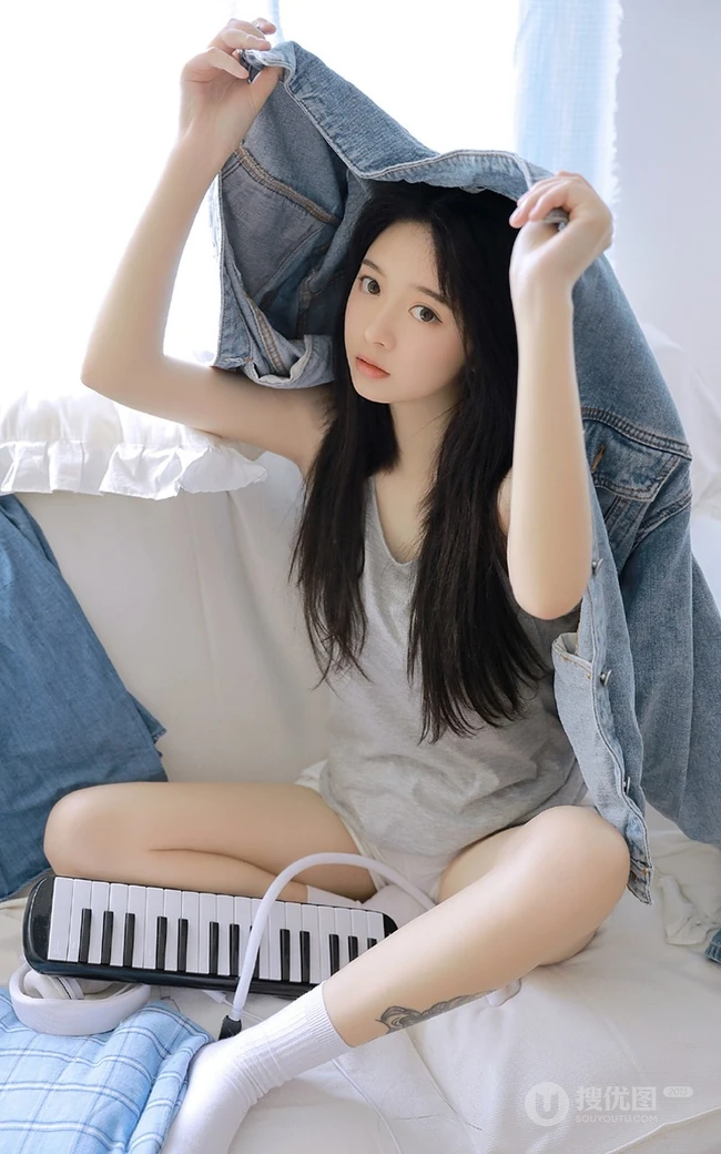 腿腕有纹身的大眼睛漂亮少女休闲T恤衫短裤居家沙发写真图片