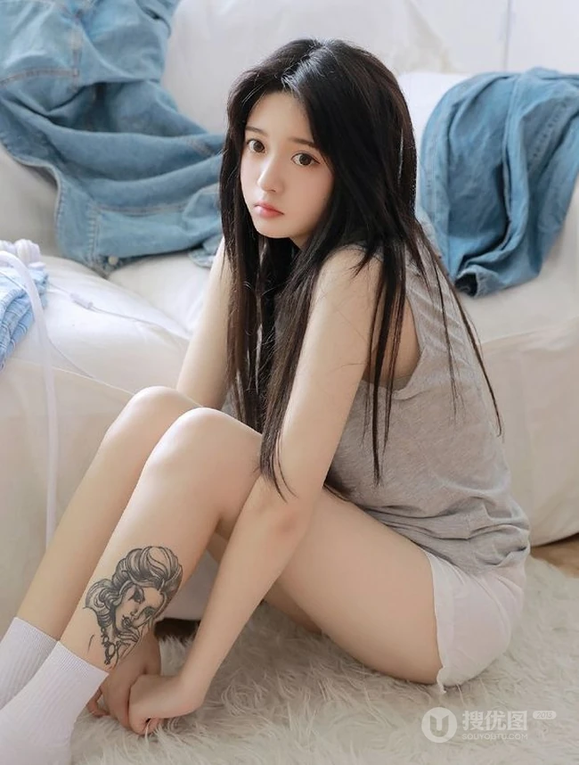 腿腕有纹身的大眼睛漂亮少女休闲T恤衫短裤居家沙发写真图片