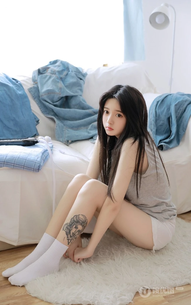 腿腕有纹身的大眼睛漂亮少女休闲T恤衫短裤居家沙发写真图片