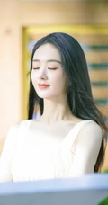 赵丽颖秀发披肩伺弄花草写真，身着肩带黄裙尽显温柔气质魅力