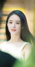 赵丽颖秀发披肩伺弄花草写真，身着肩带黄裙尽显温柔气质魅力