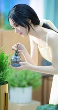 赵丽颖秀发披肩伺弄花草写真，身着肩带黄裙尽显温柔气质魅力