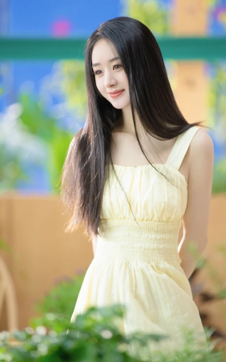 赵丽颖秀发披肩伺弄花草写真，身着肩带黄裙尽显温柔气质魅力