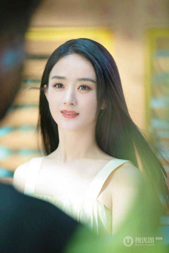 赵丽颖秀发披肩伺弄花草写真，身着肩带黄裙尽显温柔气质魅力