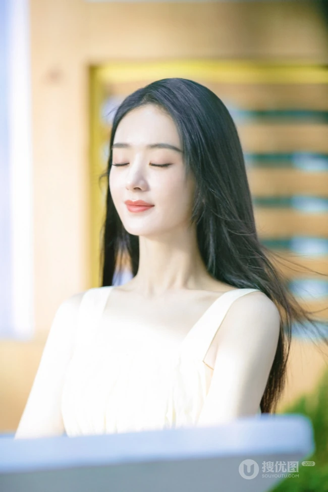 赵丽颖秀发披肩伺弄花草写真，身着肩带黄裙尽显温柔气质魅力