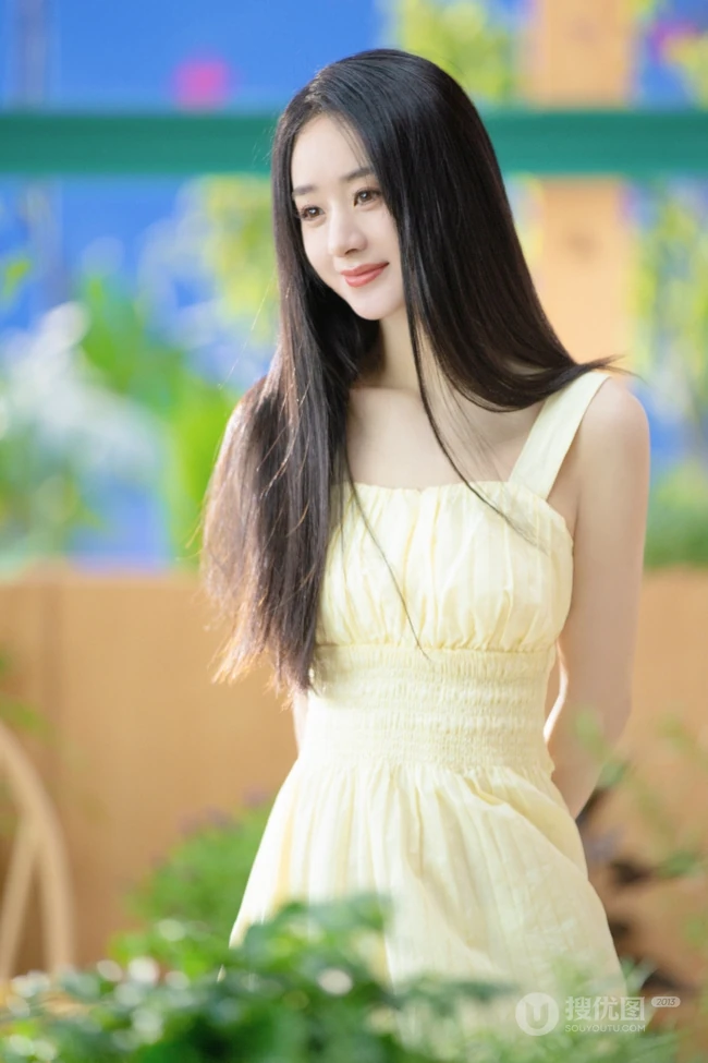 赵丽颖秀发披肩伺弄花草写真，身着肩带黄裙尽显温柔气质魅力
