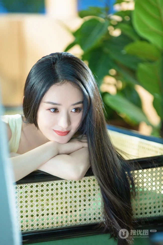 赵丽颖秀发披肩伺弄花草写真，身着肩带黄裙尽显温柔气质魅力