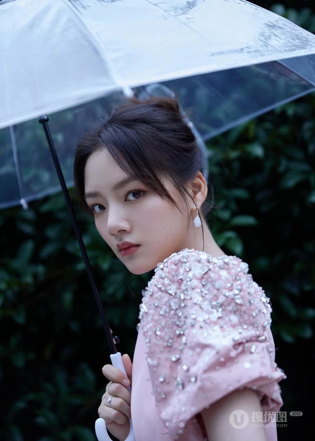 任敏身着粉裙手拿雨伞雨中漫步写真图片