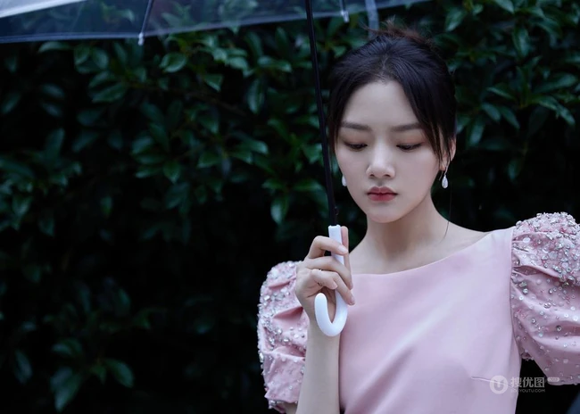 任敏身着粉裙手拿雨伞雨中漫步写真图片