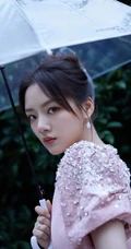 任敏身着粉裙手拿雨伞雨中漫步写真图片