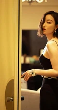 倪妮暖色室内灯光下，身着黑衣肩带裙，一举一动皆自带气质写真图片