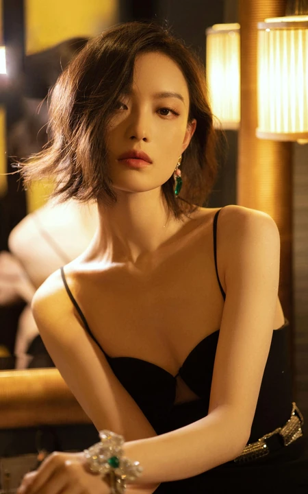 倪妮暖色室内灯光下，身着黑衣肩带裙，一举一动皆自带气质写真图片
