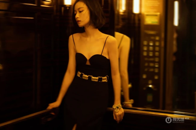 倪妮暖色室内灯光下，身着黑衣肩带裙，一举一动皆自带气质写真图片