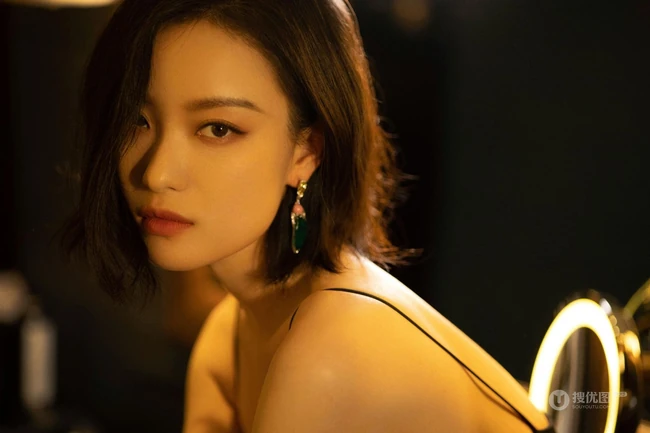 倪妮暖色室内灯光下，身着黑衣肩带裙，一举一动皆自带气质写真图片