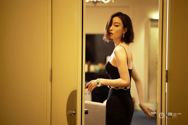 倪妮暖色室内灯光下，身着黑衣肩带裙，一举一动皆自带气质写真图片
