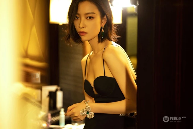 倪妮暖色室内灯光下，身着黑衣肩带裙，一举一动皆自带气质写真图片