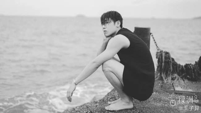 王子异头戴休闲帽搭配黑色背心短裤帅气海边写真黑白照片
