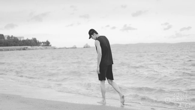王子异头戴休闲帽搭配黑色背心短裤帅气海边写真黑白照片