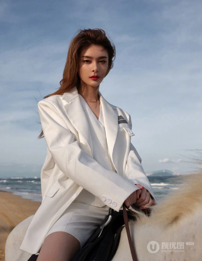 傅菁身穿白色西服套装，身骑白马 海边帅气写真图片