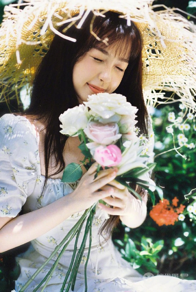 虞书欣身着印花白裙，头戴草帽徜徉花间清新清新夏日写真美照