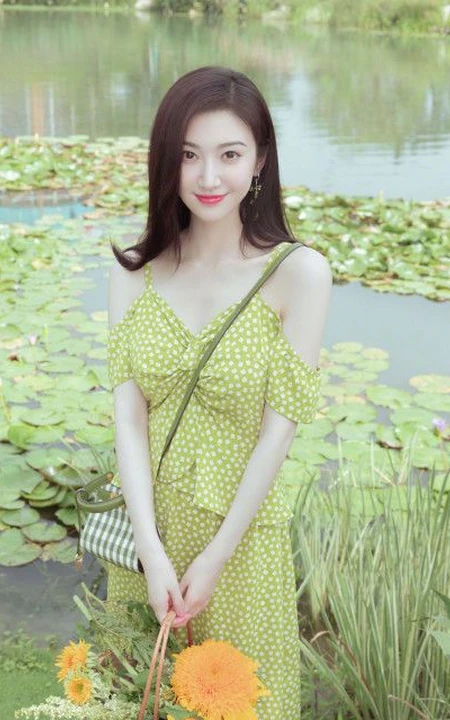 景甜清新肩带波点绿裙穿搭户外草坪间享受美食和清新空气写真图片