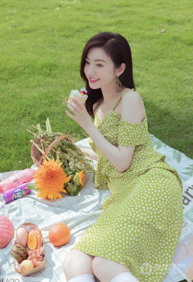 景甜清新肩带波点绿裙穿搭户外草坪间享受美食和清新空气写真图片