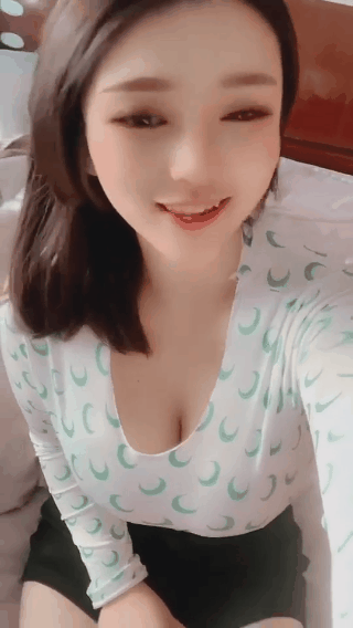 对着镜头眨眼睛的气质低领装女生GIF动态图片，最后那一下太诱人了