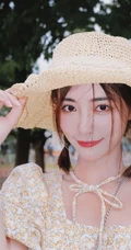 许佳琪头戴草帽，手抱猫咪，身穿小碎花裙户外清新写真图片