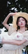 许佳琪头戴草帽，手抱猫咪，身穿小碎花裙户外清新写真图片
