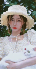 许佳琪头戴草帽，手抱猫咪，身穿小碎花裙户外清新写真图片