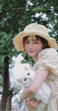 许佳琪头戴草帽，手抱猫咪，身穿小碎花裙户外清新写真图片