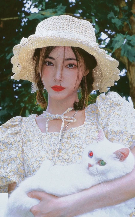 许佳琪头戴草帽，手抱猫咪，身穿小碎花裙户外清新写真图片
