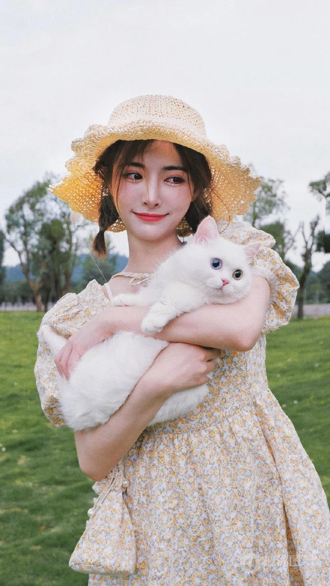 许佳琪头戴草帽，手抱猫咪，身穿小碎花裙户外清新写真图片