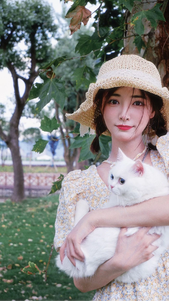 许佳琪头戴草帽，手抱猫咪，身穿小碎花裙户外清新写真图片