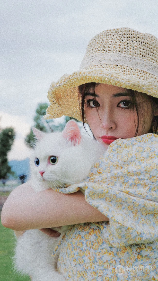 许佳琪头戴草帽，手抱猫咪，身穿小碎花裙户外清新写真图片