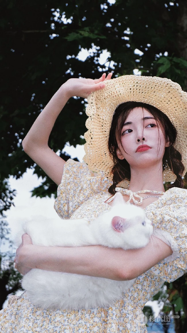 许佳琪头戴草帽，手抱猫咪，身穿小碎花裙户外清新写真图片