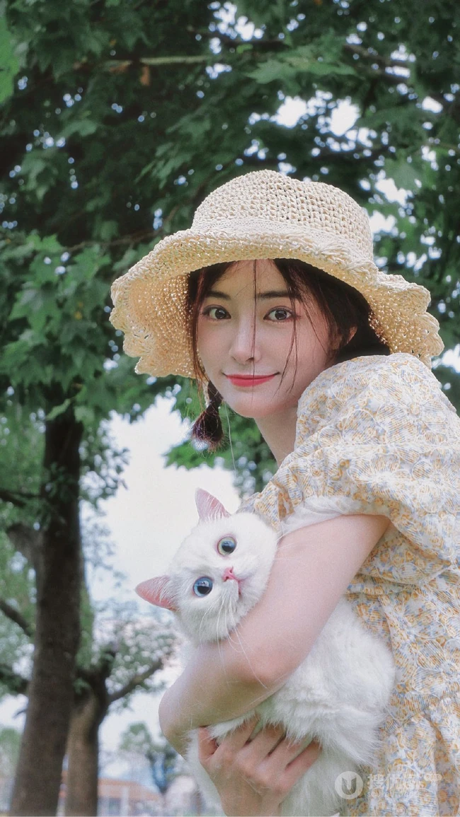 许佳琪头戴草帽，手抱猫咪，身穿小碎花裙户外清新写真图片