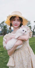 许佳琪头戴草帽，手抱猫咪，身穿小碎花裙户外清新写真图片