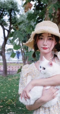 许佳琪头戴草帽，手抱猫咪，身穿小碎花裙户外清新写真图片