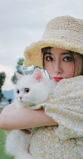 许佳琪头戴草帽，手抱猫咪，身穿小碎花裙户外清新写真图片