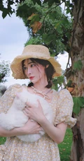 许佳琪头戴草帽，手抱猫咪，身穿小碎花裙户外清新写真图片