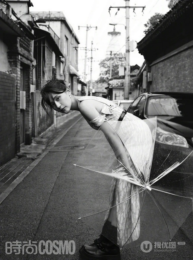 新疆女生热依扎身着长裙，手拿雨伞漫步胡同间唯美黑白写真图片