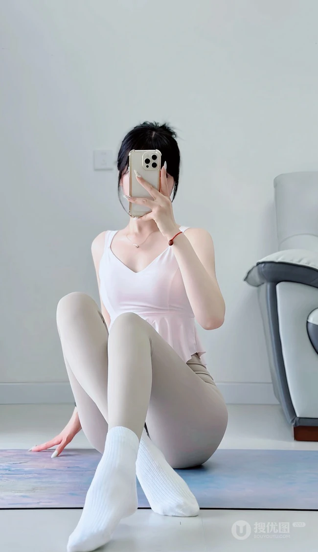 半夜起来做瑜伽的瑜伽服匀称女生手拿手机自拍展优雅身形照片