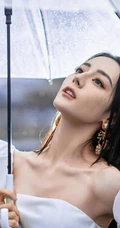 迪丽热巴纯白连衣裙穿着，手拿雨伞，雨中漫步优雅动人青春写真图片