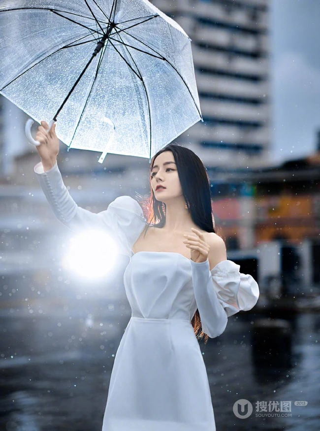 迪丽热巴纯白连衣裙穿着，手拿雨伞，雨中漫步优雅动人青春写真图片