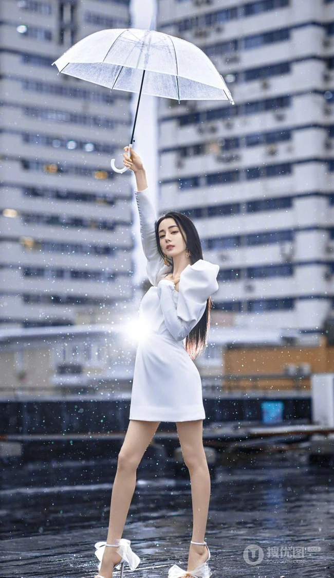 迪丽热巴纯白连衣裙穿着，手拿雨伞，雨中漫步优雅动人青春写真图片