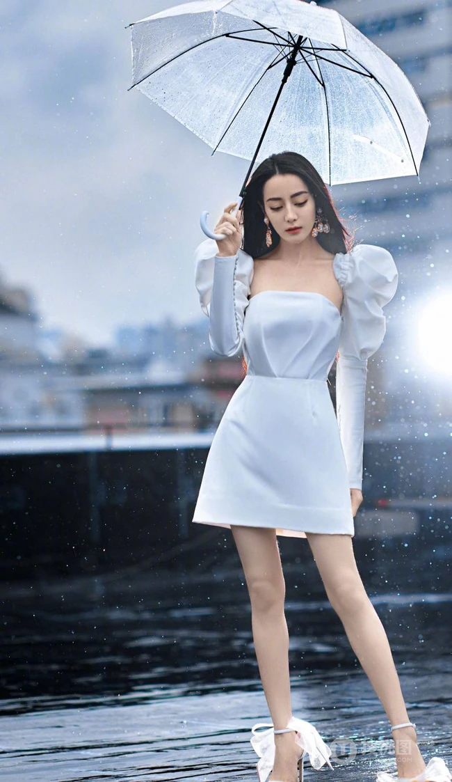 迪丽热巴纯白连衣裙穿着，手拿雨伞，雨中漫步优雅动人青春写真图片