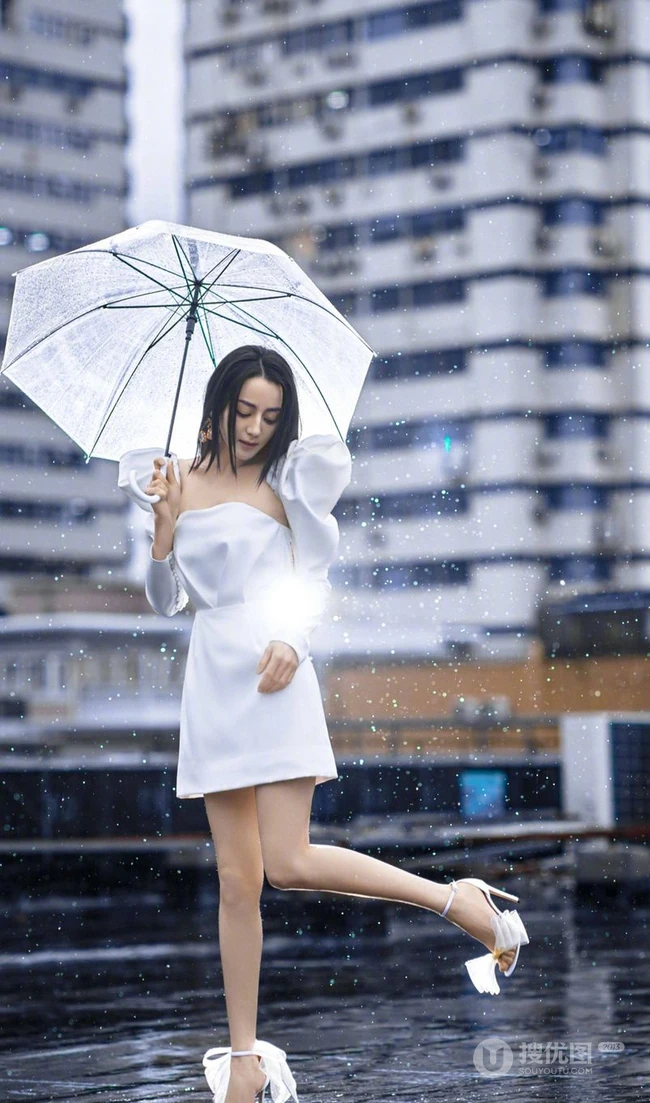 迪丽热巴纯白连衣裙穿着，手拿雨伞，雨中漫步优雅动人青春写真图片