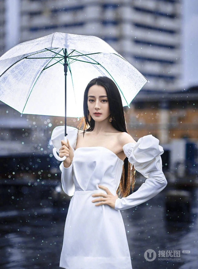 迪丽热巴纯白连衣裙穿着，手拿雨伞，雨中漫步优雅动人青春写真图片