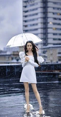 迪丽热巴纯白连衣裙穿着，手拿雨伞，雨中漫步优雅动人青春写真图片